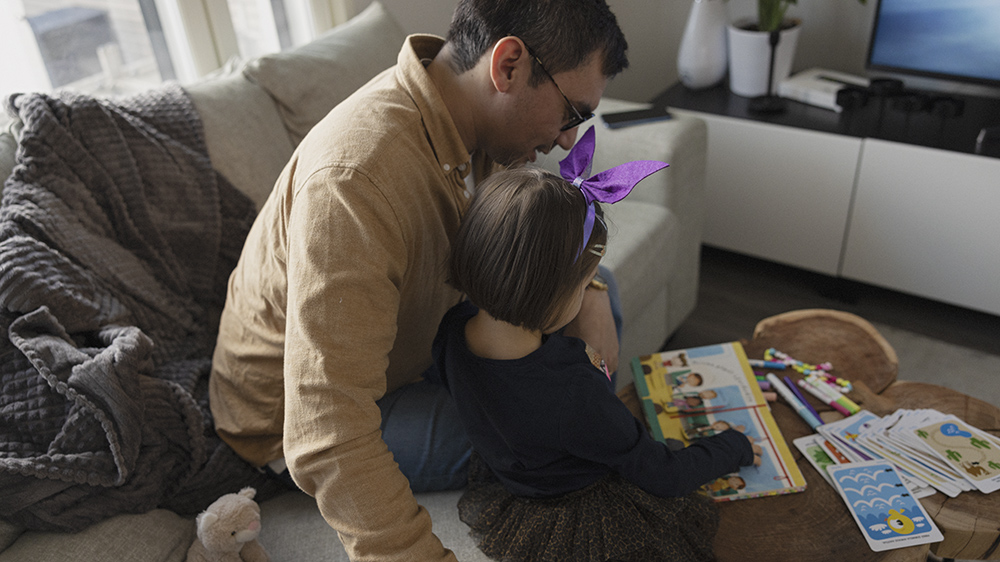 Isä ja tytär lukevat yhdessä kirjaa