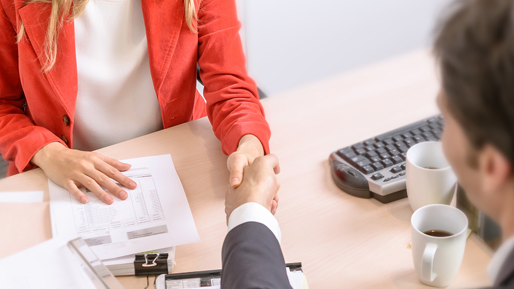 Two people shaking hands as a sign of an agreement