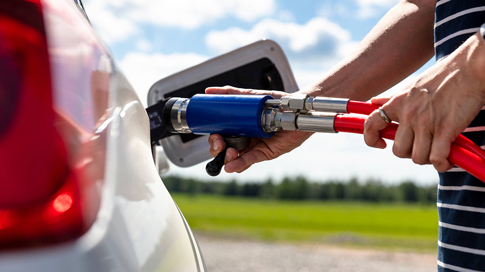 Biokaasun tankkauspistooli auton tankkausliittymään työnnettynä