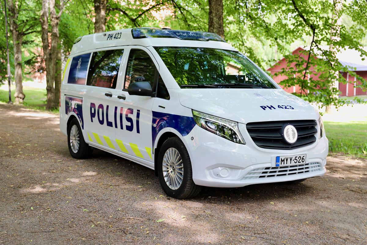 Poliisin sähköllä toimiva partioauto kesämaisemassa.